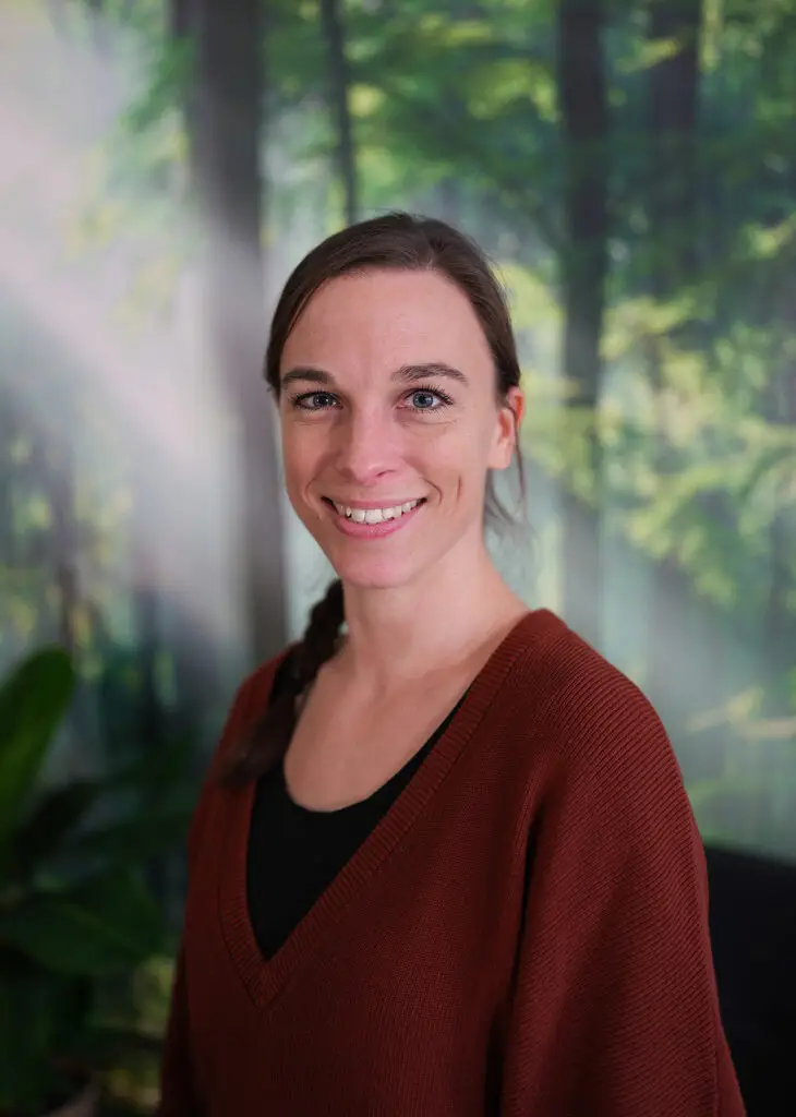 Birte Gröger steht lächelnd in ihrem Praxisraum.